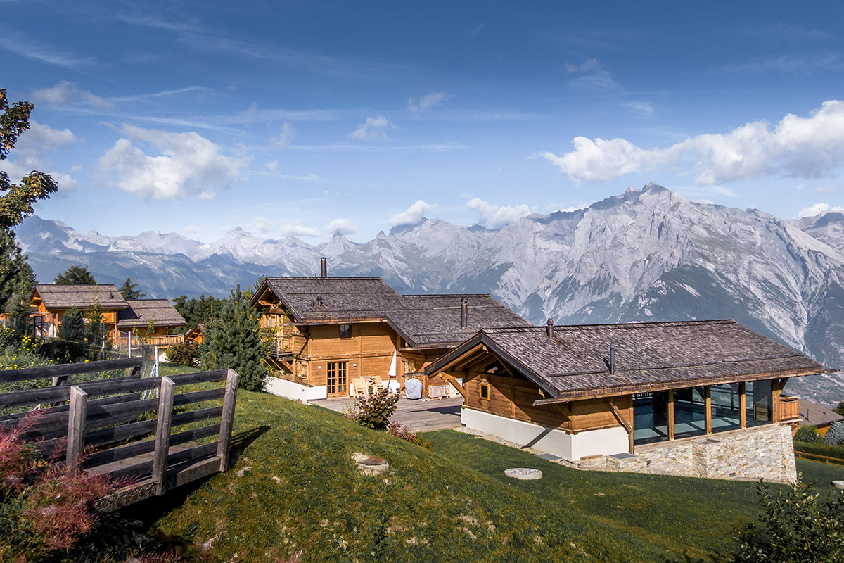 A luxury rental Chalet in Nendaz Switzerland during a nice summer day with the Swiss Alps